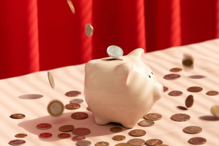 Coins falling into a piggy bank in the concept of saving money when relocating to Orpington.