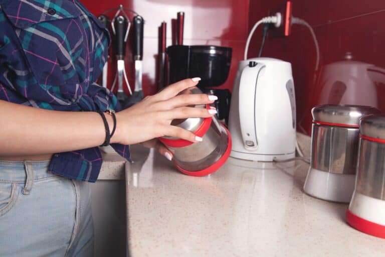 Cropped image of a woman in the kitchen with all kitchen appliances preparing coffee in the concept of 'What Types of Items Can Be Transported by a Man and Van Service in Orpington'.