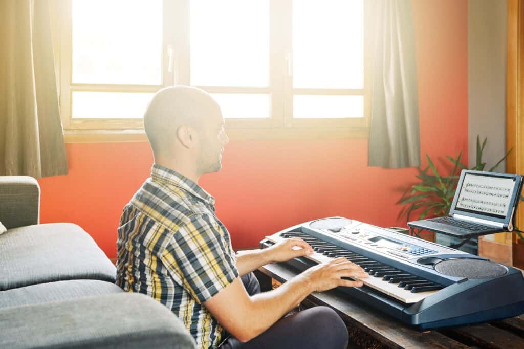 A man learning a piano piece at home