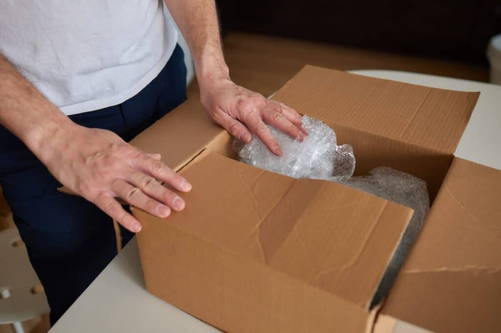 Cropped image of a professional packer handling fragile items